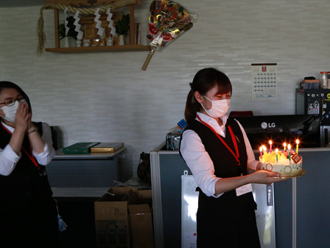 誕生日ケーキを運ぶ小泉さん